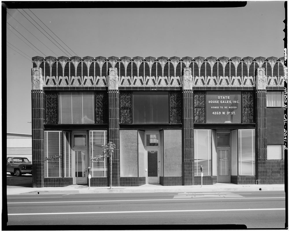 a black and white photo of an art deco style single story retail building